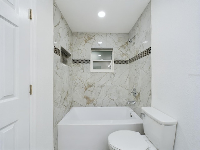 bathroom featuring tiled shower / bath combo and toilet