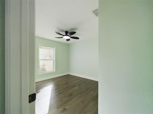 empty room with dark wood-type flooring and ceiling fan