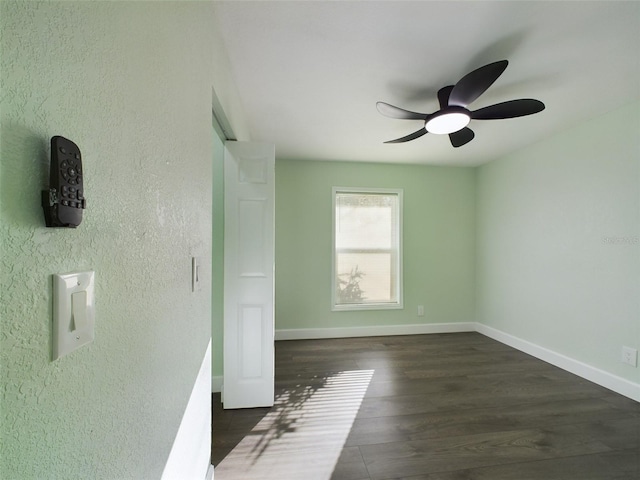 empty room with dark hardwood / wood-style flooring and ceiling fan