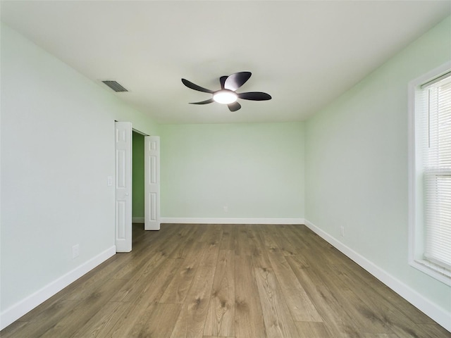 empty room with ceiling fan and light wood-type flooring