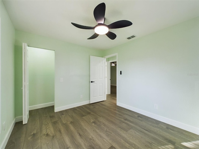 unfurnished bedroom with ceiling fan and dark hardwood / wood-style flooring