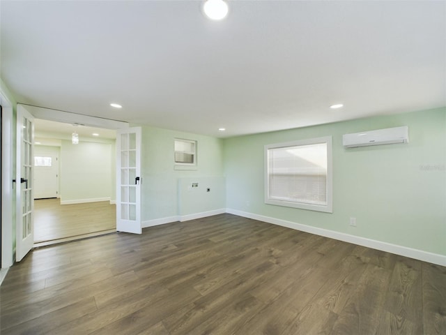 spare room with dark hardwood / wood-style flooring, french doors, and a wall mounted AC