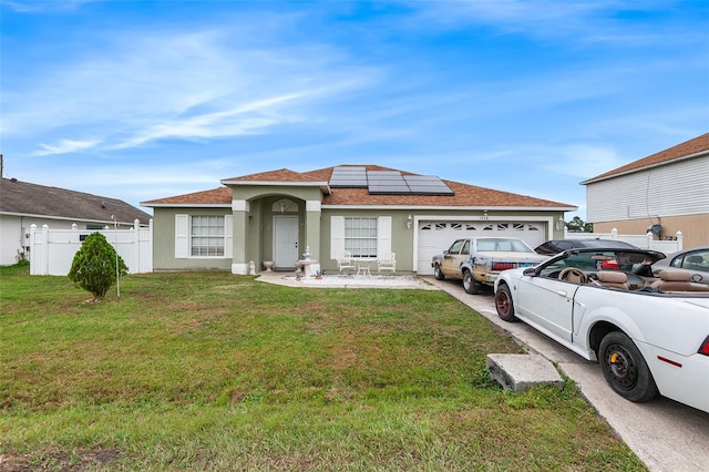 view of front of property featuring a front lawn, a garage, and solar panels