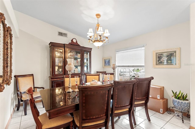 tiled dining space featuring lofted ceiling and a notable chandelier