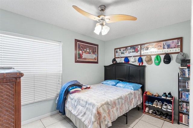 bedroom with light tile patterned floors, a textured ceiling, and ceiling fan