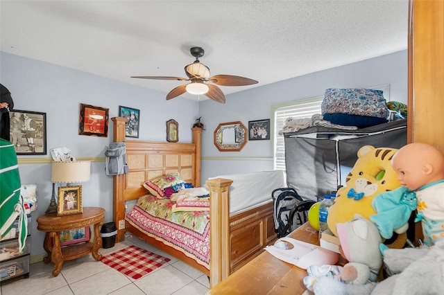 bedroom with a textured ceiling, ceiling fan, and light tile patterned flooring