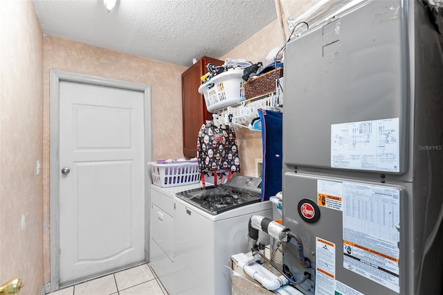 laundry room with independent washer and dryer, a textured ceiling, heating unit, and light tile patterned floors