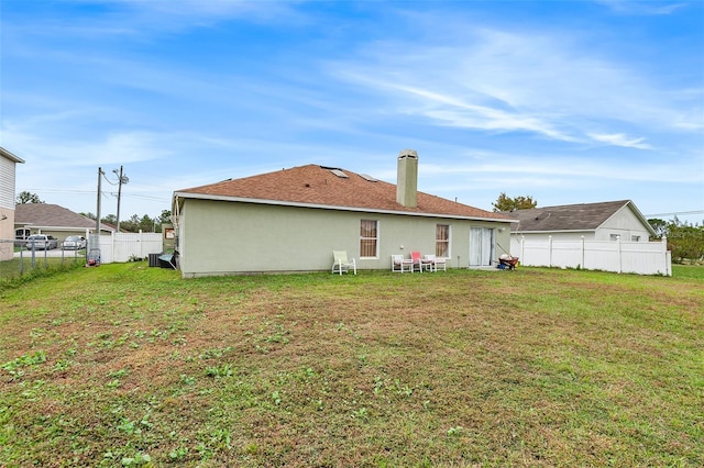 rear view of property with a lawn