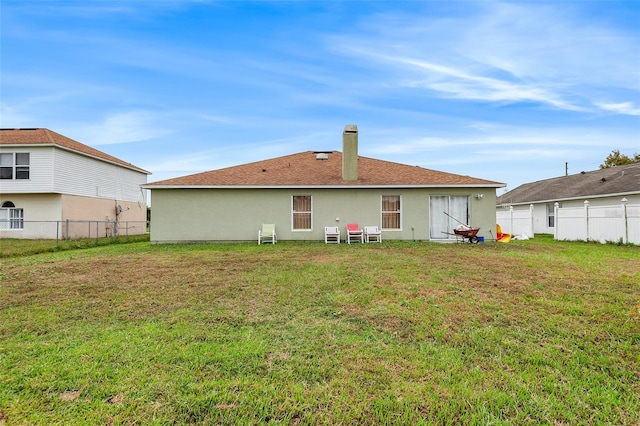 rear view of property with a lawn