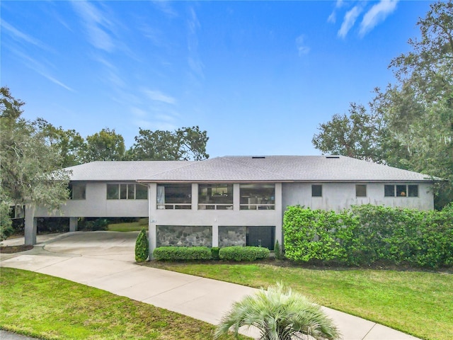 bi-level home with a front lawn and a carport