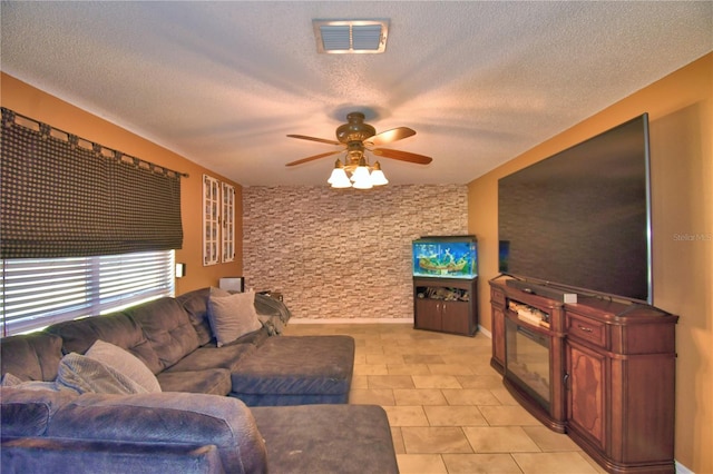 living room featuring light tile patterned floors, a textured ceiling, and ceiling fan