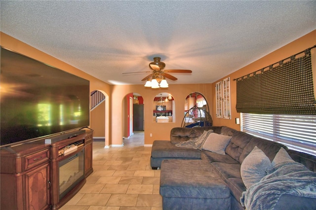 tiled living room featuring ceiling fan and a textured ceiling