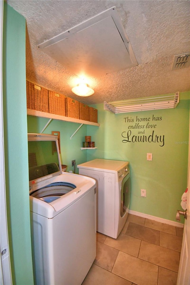 laundry room with washer and dryer, light tile patterned floors, and a textured ceiling