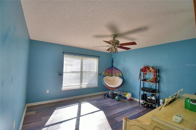 interior space with a textured ceiling, ceiling fan, and dark wood-type flooring