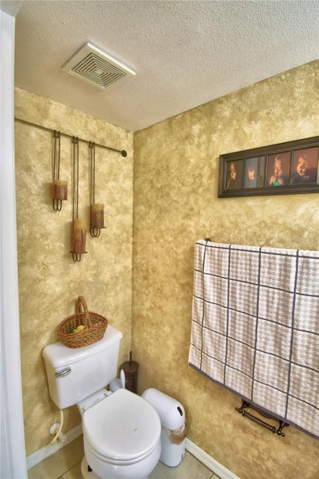 bathroom with toilet and a textured ceiling