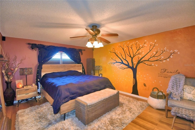 bedroom featuring hardwood / wood-style floors, ceiling fan, and a textured ceiling