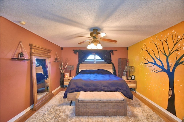 bedroom with ceiling fan, a textured ceiling, and hardwood / wood-style flooring