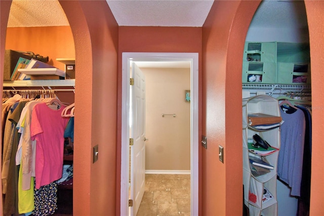 hallway with light tile patterned floors and a textured ceiling