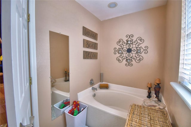 bathroom featuring tiled tub