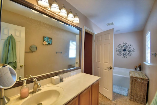 bathroom with tile patterned floors, vanity, and a bathing tub