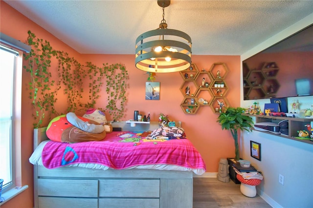 bedroom featuring hardwood / wood-style flooring, an inviting chandelier, a textured ceiling, and multiple windows