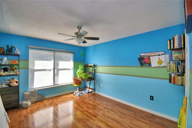 interior space with hardwood / wood-style floors, ceiling fan, and a textured ceiling