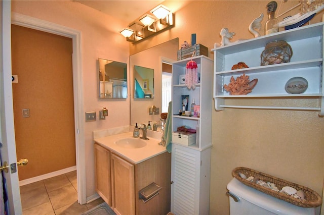 bathroom featuring tile patterned flooring, vanity, and toilet