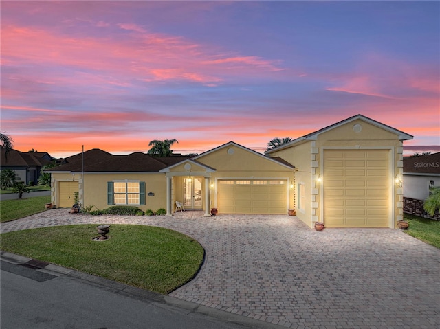 ranch-style home featuring a lawn and a garage