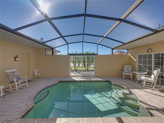 view of swimming pool featuring a patio and glass enclosure