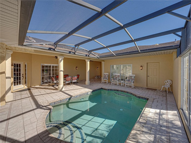 view of pool with a patio area and glass enclosure