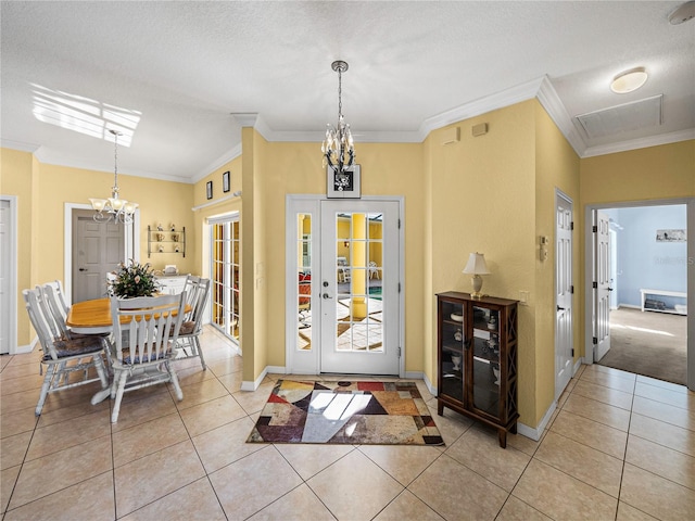 tiled entrance foyer featuring a textured ceiling, a notable chandelier, and crown molding