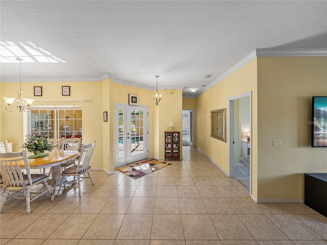 dining room with french doors, a chandelier, a textured ceiling, light tile patterned flooring, and ornamental molding