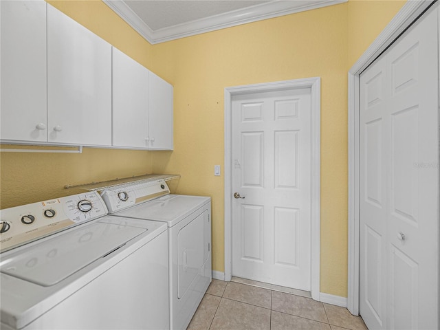 washroom with cabinets, light tile patterned floors, washing machine and dryer, and ornamental molding