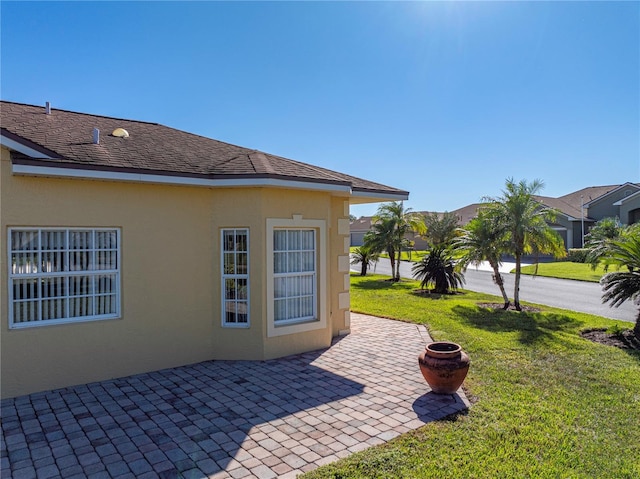 view of side of property featuring a patio area and a yard