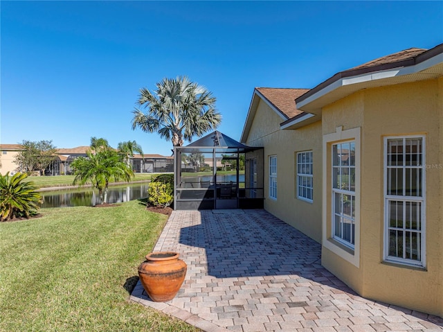 view of yard with a patio, a water view, and a sunroom