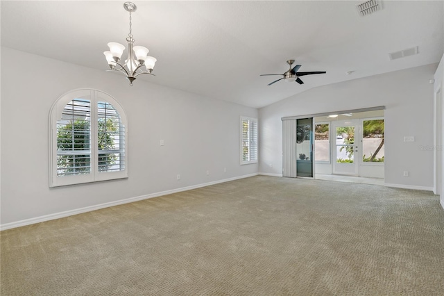 carpeted empty room with vaulted ceiling, plenty of natural light, and ceiling fan with notable chandelier