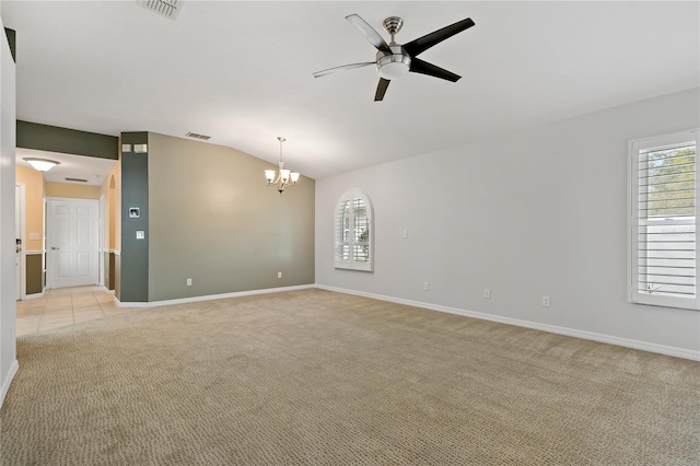 empty room featuring ceiling fan with notable chandelier, light colored carpet, and vaulted ceiling