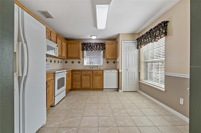 kitchen featuring light tile patterned flooring, white appliances, backsplash, and sink