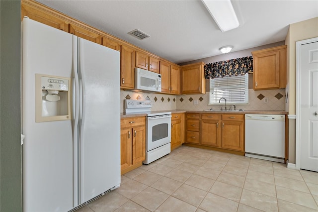 kitchen with tasteful backsplash, sink, light tile patterned floors, and white appliances