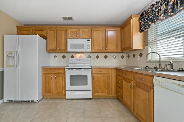 kitchen with backsplash, sink, light tile patterned flooring, and white appliances