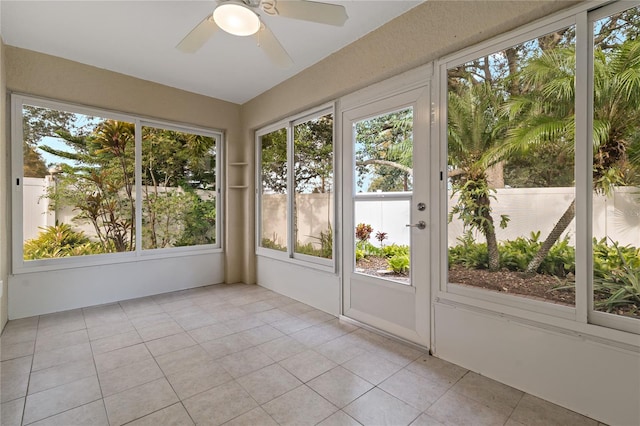 unfurnished sunroom featuring ceiling fan