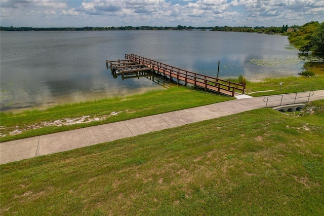 view of dock featuring a lawn and a water view