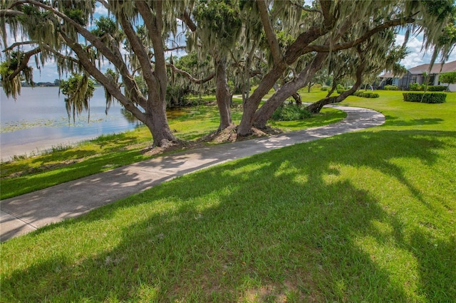 view of home's community featuring a lawn and a water view