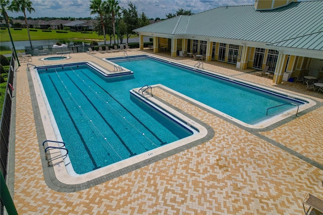 view of swimming pool featuring a patio area and a hot tub