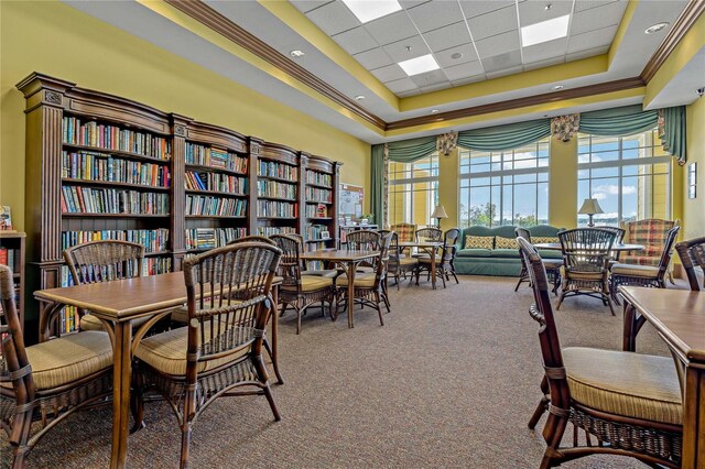 interior space with a high ceiling, a tray ceiling, a paneled ceiling, carpet, and ornamental molding