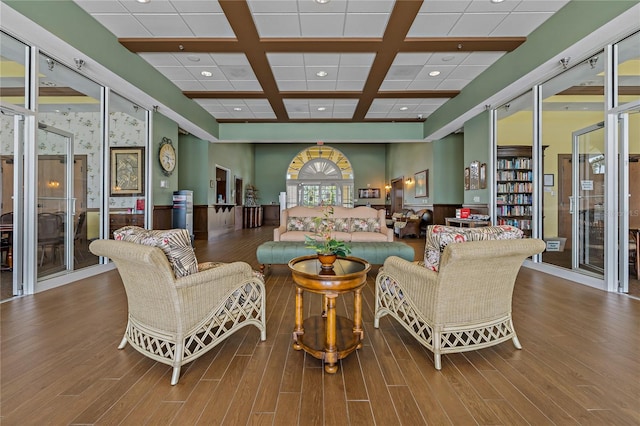 living room with beam ceiling, wood-type flooring, and coffered ceiling