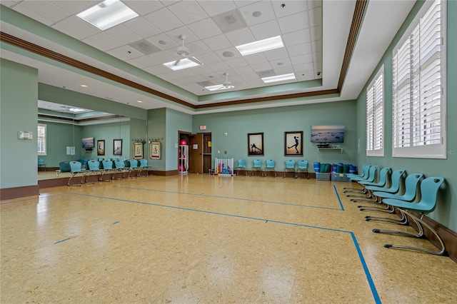 interior space with a tray ceiling, a paneled ceiling, basketball hoop, and ornamental molding