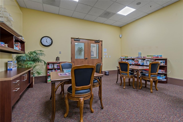 carpeted dining room featuring a paneled ceiling