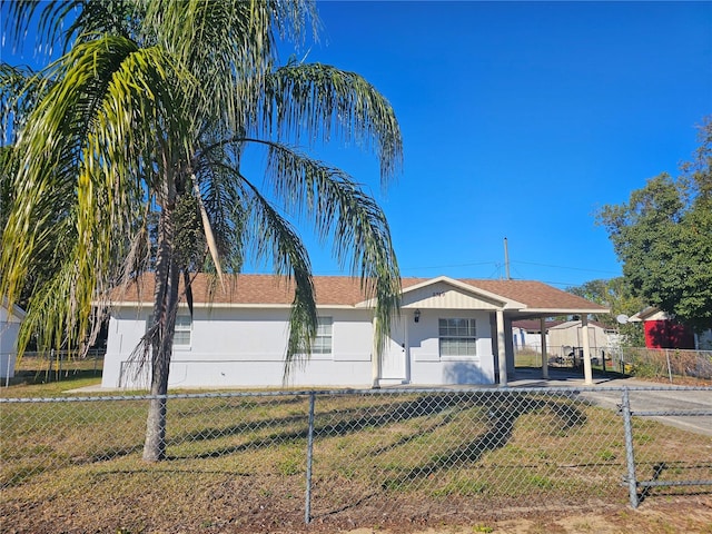 ranch-style home with a front yard and a carport