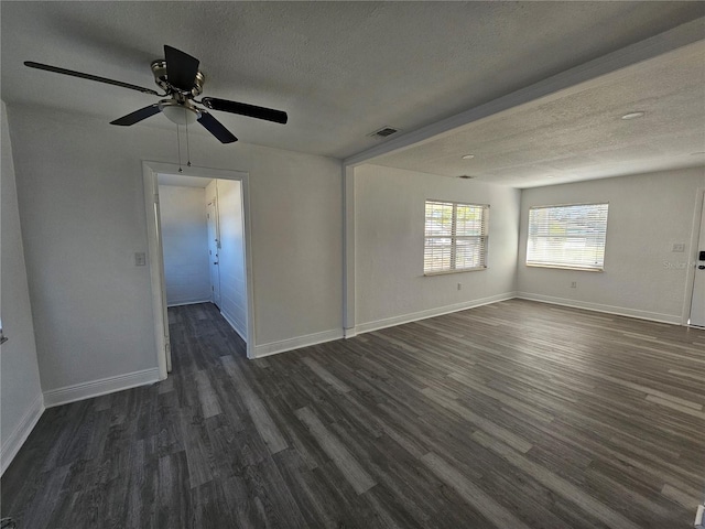 empty room with ceiling fan, dark hardwood / wood-style flooring, and a textured ceiling